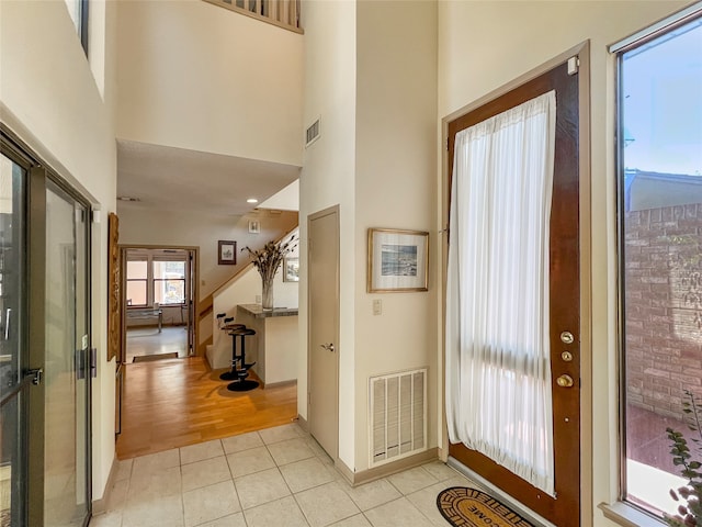 tiled foyer entrance featuring a towering ceiling