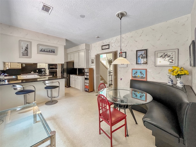 dining area with sink and a textured ceiling