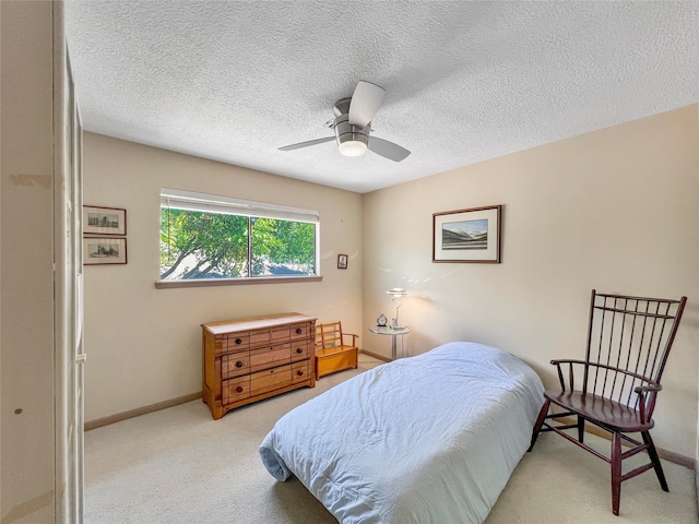 carpeted bedroom with ceiling fan and a textured ceiling