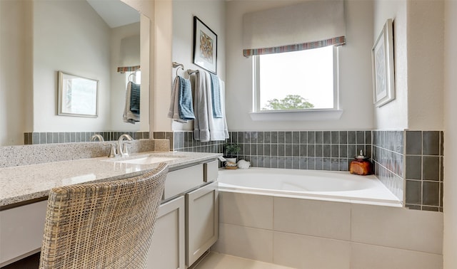 bathroom with tiled bath and vanity