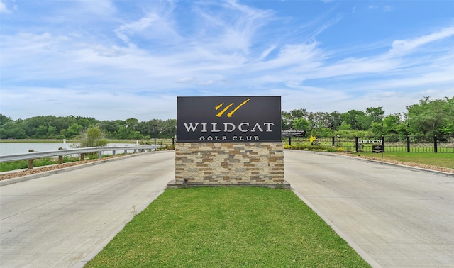 community sign with a water view and a yard