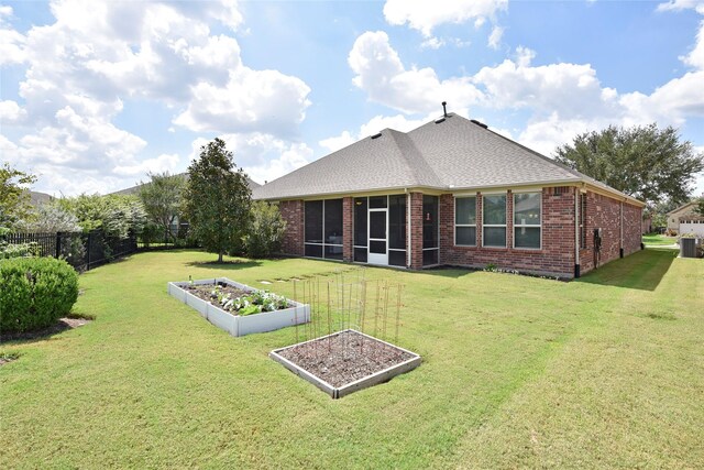 rear view of property featuring a yard and a sunroom