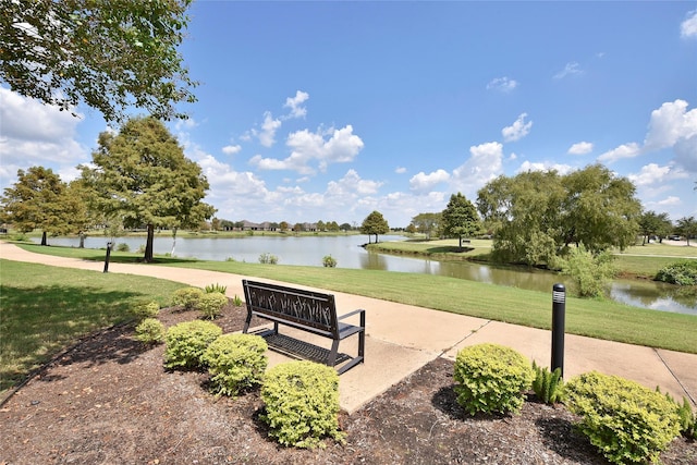 surrounding community featuring a water view and a lawn