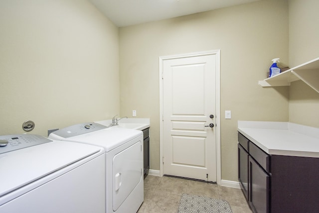 clothes washing area with sink, light tile patterned flooring, cabinets, and washer and dryer