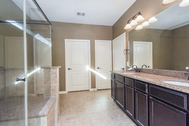 bathroom with a shower, vanity, and tile patterned flooring