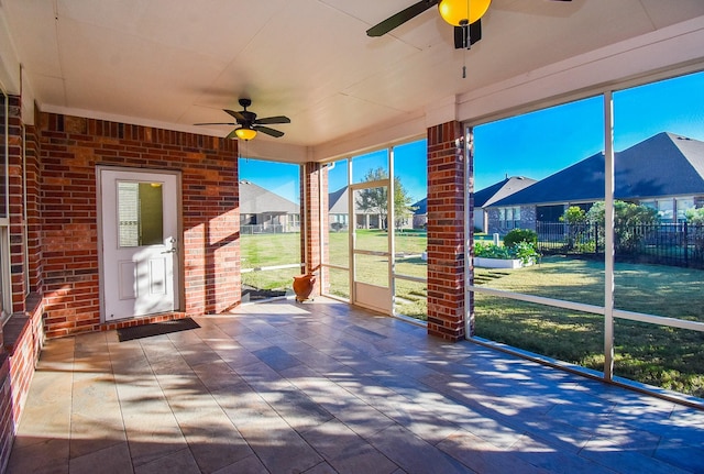 unfurnished sunroom featuring ceiling fan