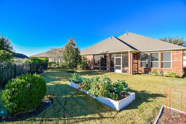 rear view of property with a sunroom and a yard