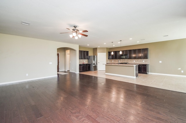 unfurnished living room featuring ceiling fan and light wood-type flooring