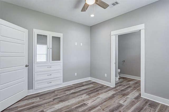 unfurnished bedroom featuring ceiling fan, hardwood / wood-style flooring, and connected bathroom