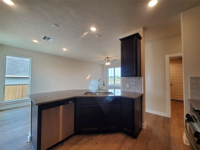 kitchen featuring kitchen peninsula, sink, stainless steel dishwasher, and light wood-type flooring