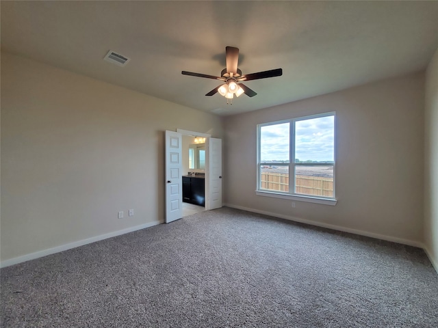 unfurnished bedroom featuring carpet floors, ensuite bathroom, and ceiling fan