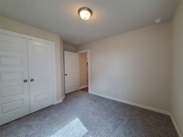 unfurnished bedroom featuring carpet and a closet