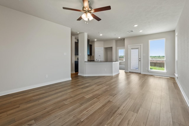 1409 Whitney Ln, Brenham, TX 77833 - unfurnished living room featuring recessed lighting, wood finished floors, visible vents, baseboards, and ceiling fan