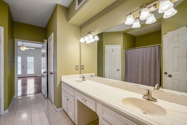 bathroom with tile patterned flooring, vanity, ceiling fan, and french doors