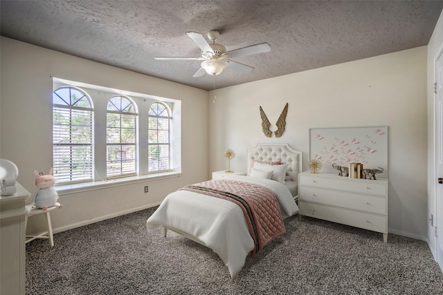 bedroom featuring dark colored carpet, a textured ceiling, and ceiling fan