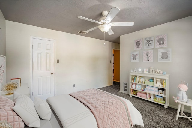 bedroom featuring a textured ceiling, dark carpet, and ceiling fan