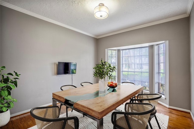 dining space with hardwood / wood-style flooring, crown molding, and a textured ceiling