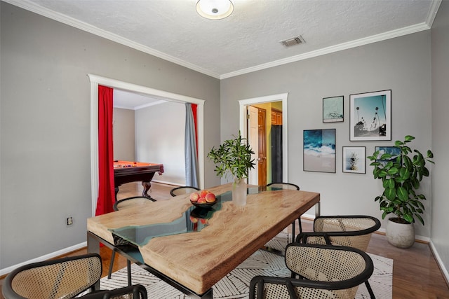 dining area with a textured ceiling, hardwood / wood-style flooring, crown molding, and billiards