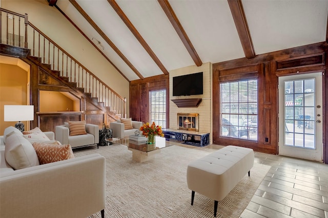 living room featuring a fireplace, high vaulted ceiling, and beamed ceiling