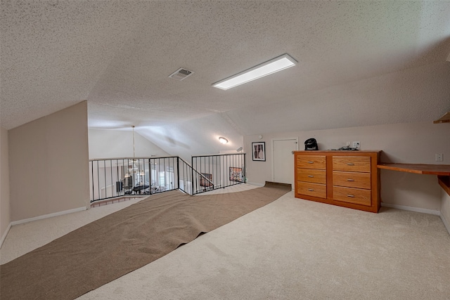 additional living space featuring light carpet, a textured ceiling, and lofted ceiling