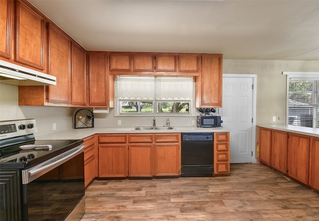 kitchen with light wood-type flooring, black appliances, and sink