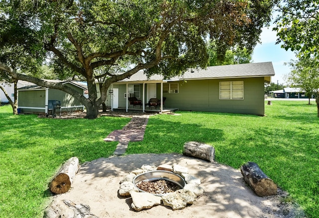 rear view of house with a yard, a fire pit, and a patio area