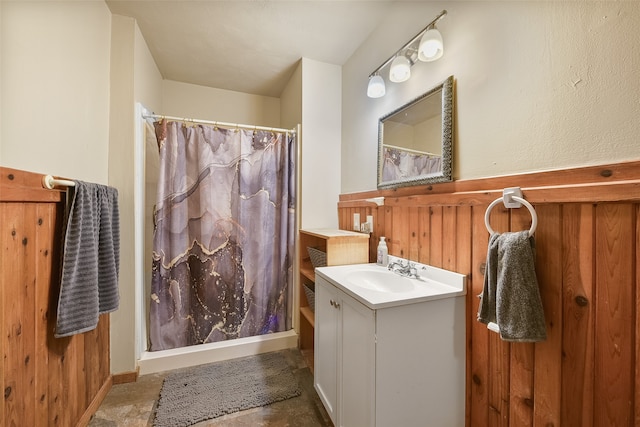 bathroom with a shower with curtain, vanity, and wood walls