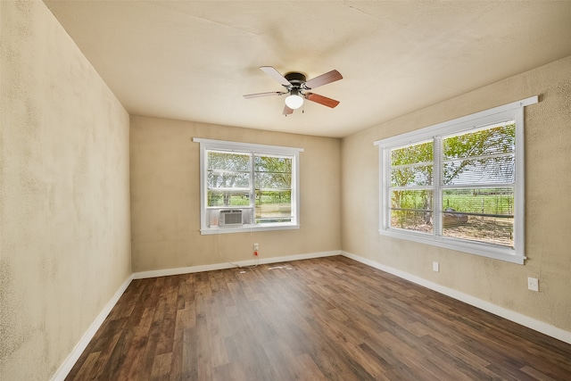 spare room featuring cooling unit, dark hardwood / wood-style floors, and ceiling fan