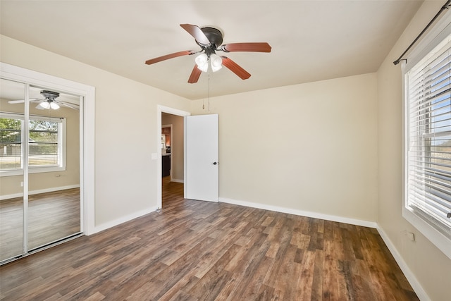 unfurnished bedroom with dark hardwood / wood-style flooring, ceiling fan, and a closet