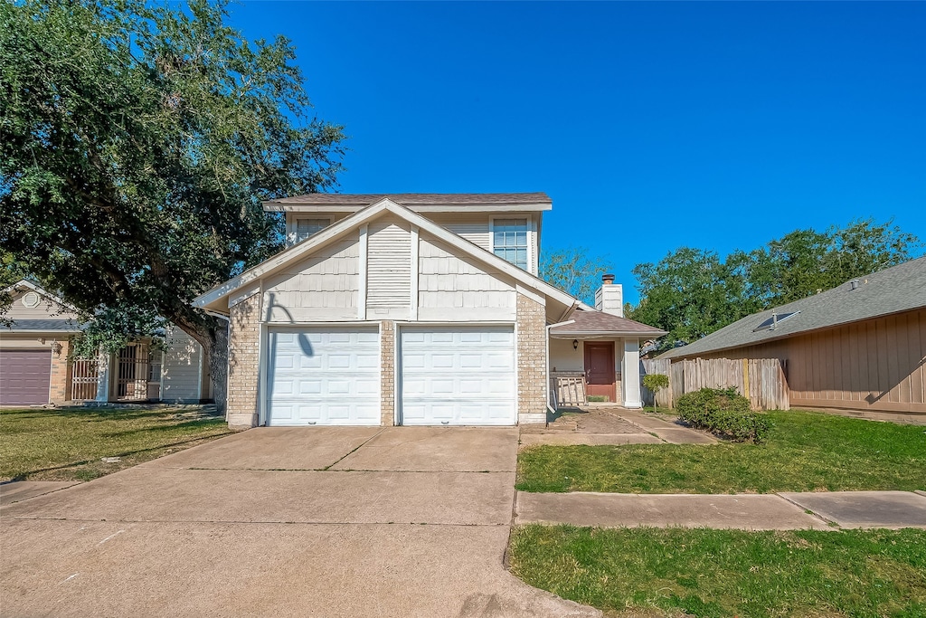 view of property featuring a front yard and a garage