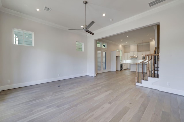 unfurnished living room with ceiling fan, light wood-type flooring, and crown molding