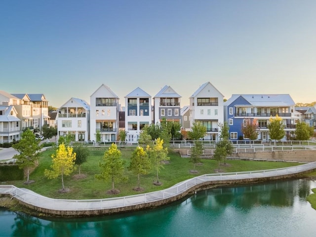 exterior space with a yard, a balcony, and a water view