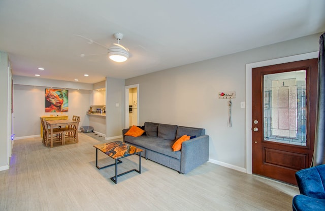 living room with light hardwood / wood-style floors and ceiling fan