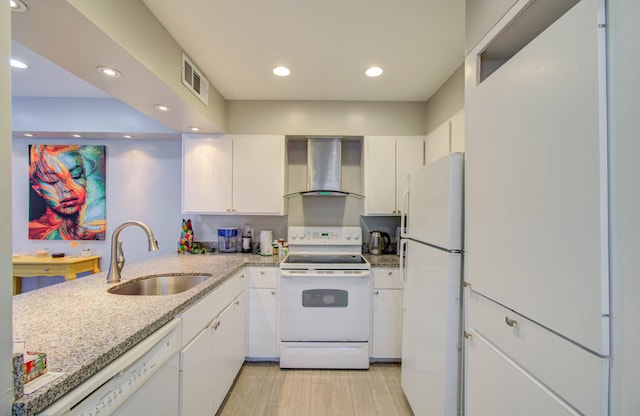 kitchen featuring wall chimney exhaust hood, kitchen peninsula, sink, white cabinetry, and white appliances