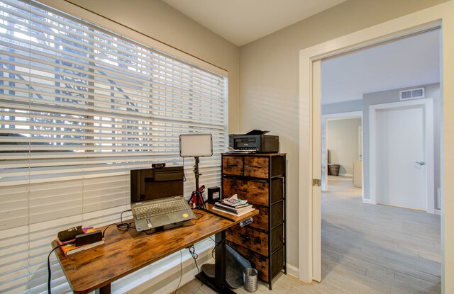 home office with light hardwood / wood-style floors