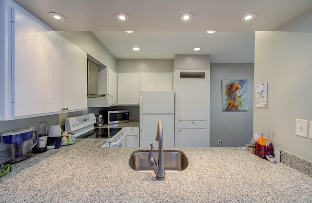 2575 Marilee Ln Unit 1, Houston, TX 77057 - kitchen featuring white appliances, white cabinets, wall chimney range hood, recessed lighting, and light stone counters