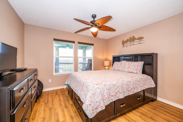 bedroom featuring light hardwood / wood-style flooring, ceiling fan, and a textured ceiling