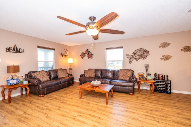 living room with ceiling fan and light hardwood / wood-style flooring