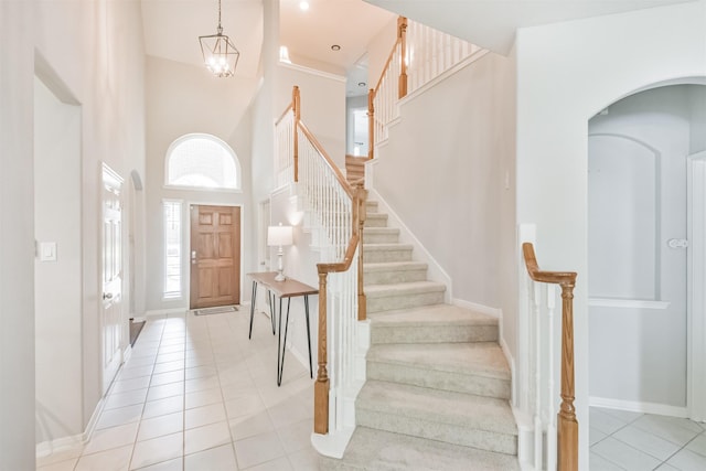 entrance foyer with a high ceiling, light tile patterned floors, and a notable chandelier