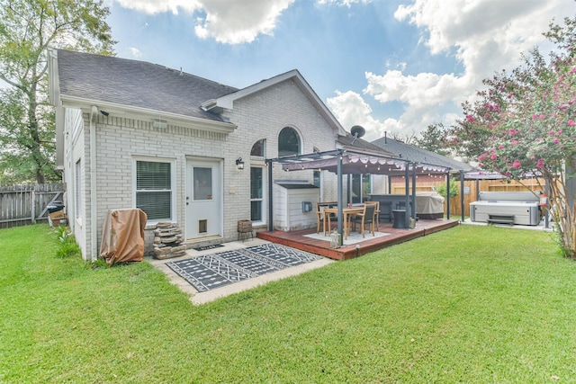 back of house featuring a lawn, a hot tub, a pergola, and a wooden deck