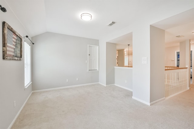 carpeted empty room featuring lofted ceiling