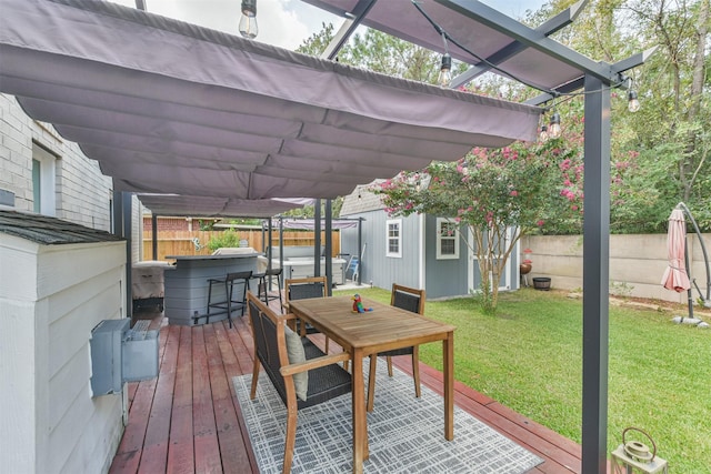 wooden terrace featuring a pergola, a hot tub, a lawn, and an outdoor structure