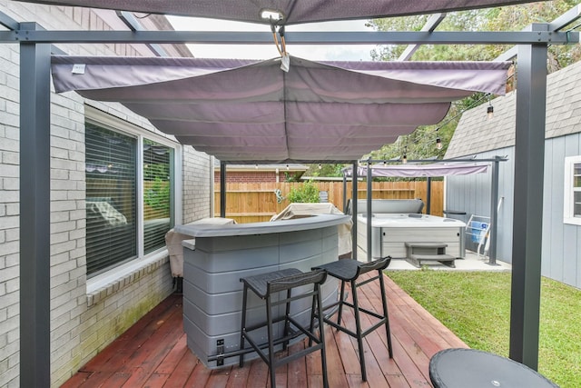 wooden deck with a pergola, a hot tub, and exterior bar