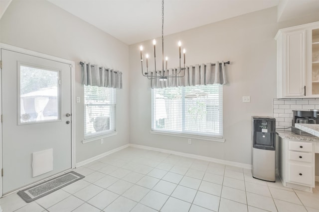 kitchen with pendant lighting, white cabinets, decorative backsplash, a chandelier, and light tile patterned floors