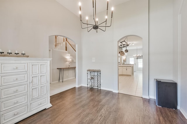 unfurnished dining area with a high ceiling and wood-type flooring