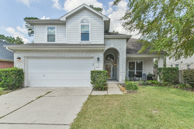 view of property featuring a garage, a front lawn, and covered porch