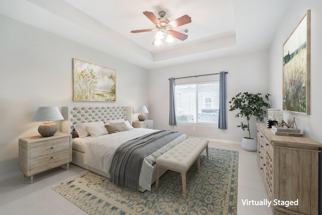 bedroom with ceiling fan and a raised ceiling