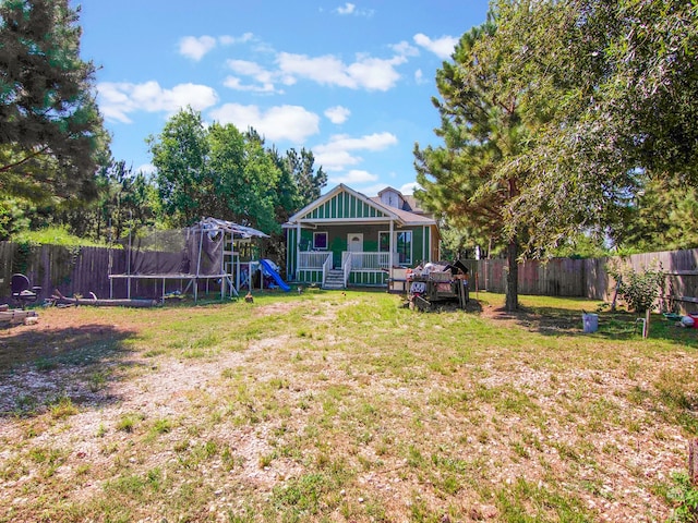 view of yard with a trampoline and a playground