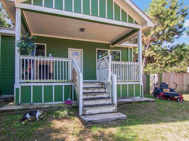 entrance to property featuring fence and a porch