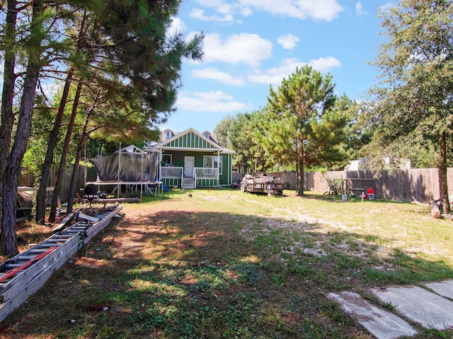 view of yard featuring a trampoline and fence